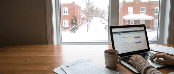 A graduate getting PGWP application documents ready at a kitchen table